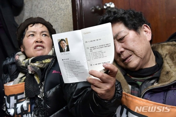 '5월 어머니회' 등 5·18 희생자와 부상자 가족들이 14일 서울 여의도 국회 자유한국당 원내대표실 앞에서 극우 논객 지만원씨가 배포한 소책자를 들어 보이며 항의하고 있다.