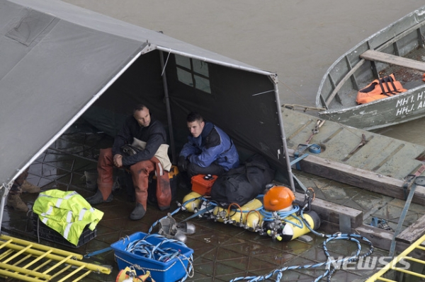 지난 30일(현지시간) 헝가리 유람선 침몰사고가 발생한 부다페스트 다뉴브강 사고 지점에 구조대원들이 구조작업을 벌이고 있는 가운데 잠수부들이 대기하고 있다.