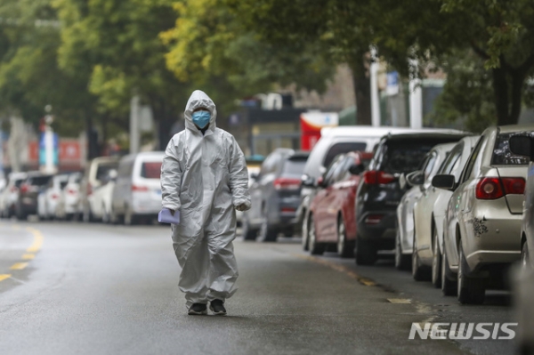 신종 코로나바이러스 진원지인 중국 후베이성 우한시에서 27일 보호장비를 착용한 의료진이 인적 끊긴 거리를 걷고 있다.