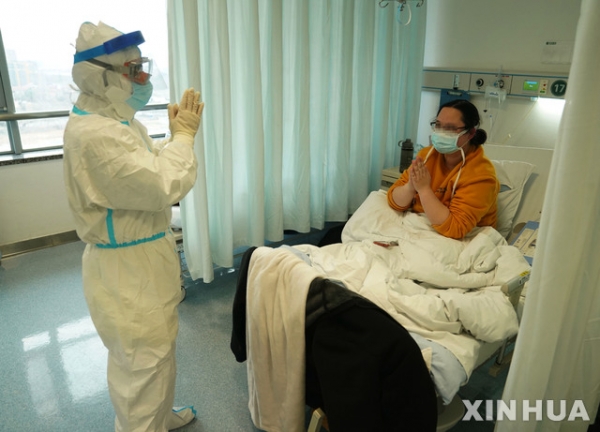 18일(현지시간) 중국 후베이성 우한의 한 병원에서 신종 코로나바이러스 감염증(코로나19) 치료를 받는 한 여성이 주치의인 자오젠핑 주임교수에게 고마움의 인사를 하고 있다. 이 여성은 코로나19 치료 중 아들을 출산했으며 태어난 아이는 의료진의 의학적 관찰을 받고 있다