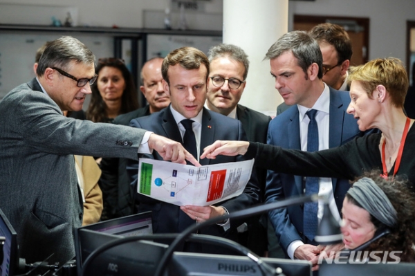 에마뉘엘 마크롱 프랑스 대통령(가운데)이 10일(현지시간) 파리의 한 응급의료소를 방문해 신종 코로나바이러스 감염증(코로나19)에 관한 설명을 듣고 있다.