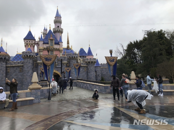 13일(현지시간) 미 캘리포니아주 애너하임의 디즈니랜드에서 관광객들이 사진을 찍고 있다. 디즈니랜드는 신종 코로나바이러스 감염증의 확산으로 14일부터 이달 말까지 리조트 전체를 폐쇄한다. 2020.03.14.