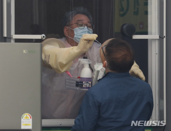해외입국자 전용 신종 코로나바이러스 감염증(코로나19) 워킹스루 선별진료소가 설치된 3일 오후 서울 잠실종합운동장에서 의료진이 해외 입국자들의 검체 채취 하고 있다.