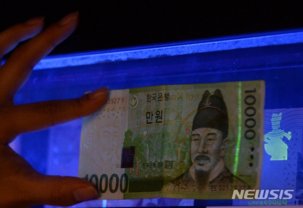 서울 중구 한국은행 화폐박물관 기획전시실에서 관람객들이 실제 화폐에 자외선을 비춰 위폐인지 확인하고 있다. (사진=뉴시스 DB) 2020.11.11.