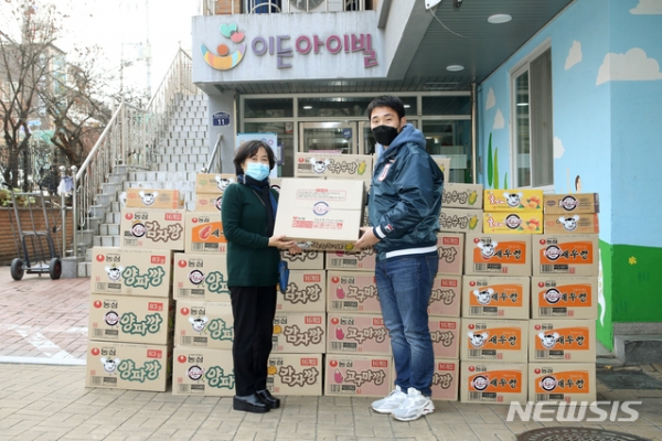 두산 베어스 김인태(오른쪽)가 포스트시즌 받은 과자를 구단 대표로 보육 시설에 전달하고 있다. (사진=두산 제공)