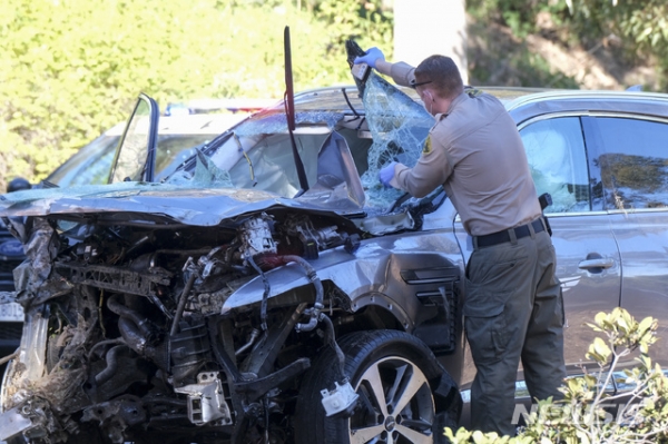미 프로골퍼 타이거 우즈가 타고 있던 차량이 23일(현지시간) 미 캘리포니아주 로스앤젤레스 카운티 란초 팔로스 베르데스 인근에서 전복돼 한 경찰관이 사고 차량인 제네시스 GV80을 살펴보고 있다. 우즈는 이 사고로 다리를 다쳐 병원으로 이송돼 수술을 받고 있다고 그의 매니저 마크 스타인버그가 밝혔다. 2021.02.24.