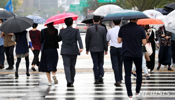 이영환 기자 = 가을비가 내리고 있는 지난 8일 오후 서울 종로구 광화문네거리에서 시민들이 우산을 쓰고 걸어가고 있다. 2021.10.08. 20hwan@newsis.com