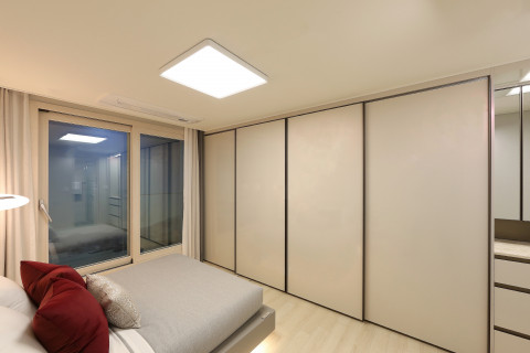 LX하우시스 리사이클 가구용 필름이 붙박이장 표면 마감재로 적용된 두산위브더제니스 오션시티 모델하우스의 침실 공간